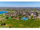 Expansive aerial view of neighborhood with a lake, park, tennis courts, and playground at 12421 W Fair Dr, Littleton, CO 80127