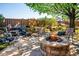 Relaxing backyard with stone patio, fire pit, lush landscaping, waterfall feature, and perimeter privacy fence at 12421 W Fair Dr, Littleton, CO 80127