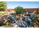 Private backyard oasis with a waterfall feature, stone patio, seating area, lush landscaping, and perimeter fencing at 12421 W Fair Dr, Littleton, CO 80127