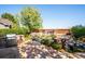 Serene backyard oasis featuring stone patio, built-in grill, lush landscaping, seating area, and perimeter fencing at 12421 W Fair Dr, Littleton, CO 80127