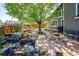 Enjoy this cozy backyard with a stone fire pit and patio next to mature trees and a small rock waterfall feature at 12421 W Fair Dr, Littleton, CO 80127