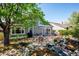 Backyard with stone patio, BBQ, table and mature trees for shade at 12421 W Fair Dr, Littleton, CO 80127