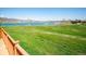 Breathtaking backyard view of a lush greenbelt and a serene lake with a mountain backdrop at 12421 W Fair Dr, Littleton, CO 80127
