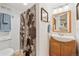Bathroom with wood vanity, and a shower with a decorative curtain at 12421 W Fair Dr, Littleton, CO 80127