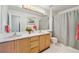 Bright bathroom features double sinks, a framed mirror and shower with a gray curtain at 12421 W Fair Dr, Littleton, CO 80127