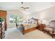 Spacious bedroom features an ornate wooden bed frame, vaulted ceilings, and a ceiling fan at 12421 W Fair Dr, Littleton, CO 80127