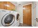 Laundry room featuring a side-by-side washer and dryer and wood cabinets for storage at 12421 W Fair Dr, Littleton, CO 80127