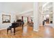 Open living room boasting hardwood floors and a grand piano at 12421 W Fair Dr, Littleton, CO 80127