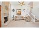 Inviting living room with brick fireplace, neutral tones, large windows, and staircase access for a cozy ambiance at 12421 W Fair Dr, Littleton, CO 80127