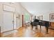 Inviting living room with hardwood floors, piano, and front door at 12421 W Fair Dr, Littleton, CO 80127