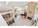 Open-concept living space with a kitchen, brick fireplace, and expansive windows at 12421 W Fair Dr, Littleton, CO 80127