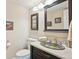 Elegant powder room with decorative sink, granite countertop, and framed artwork on the walls at 12421 W Fair Dr, Littleton, CO 80127