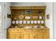 Vintage wooden cabinet with display shelves showcasing a collection of decorative plates and pottery at 3168 W 29Th Ave, Denver, CO 80211