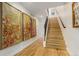 Bright hallway with hardwood floors, modern art pieces, and a staircase leading upstairs at 3168 W 29Th Ave, Denver, CO 80211