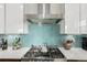 Modern kitchen features stainless steel appliances, a blue tile backsplash, and white cabinets at 3168 W 29Th Ave, Denver, CO 80211