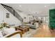 Open-concept living room with hardwood floors, a modern staircase, and a gray sofa at 3168 W 29Th Ave, Denver, CO 80211