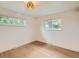 Light-filled bedroom boasting hardwood floors, two bright windows, and a modern light fixture at 22 Rangeview Dr, Wheat Ridge, CO 80215