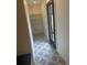 Bright entryway featuring stylish geometric tile flooring, built-in shelving, and a glass door leading to the outside at 22 Rangeview Dr, Wheat Ridge, CO 80215