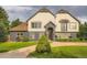Charming two-story home boasts a unique facade, a manicured lawn, and beautiful landscaping at 22 Rangeview Dr, Wheat Ridge, CO 80215