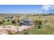 Aerial view of a two-story home with a three-car garage, stone accents, and lush landscaping in a rural setting at 2339 Elkhorn St, Parker, CO 80138
