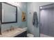 Bathroom featuring stylish sink, granite countertop, framed mirror, toilet, and tiled shower at 2339 Elkhorn St, Parker, CO 80138