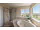 This bathroom features a glass enclosed shower and soaking tub under a bright window at 2339 Elkhorn St, Parker, CO 80138
