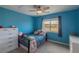 Blue bedroom featuring a ceiling fan, a window and a white dresser at 2339 Elkhorn St, Parker, CO 80138