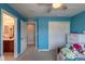 Blue bedroom with ceiling fan leading into a bathroom with double sinks at 2339 Elkhorn St, Parker, CO 80138