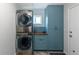 Convenient laundry room with stacked washer and dryer, storage cabinets, and a countertop work area at 2339 Elkhorn St, Parker, CO 80138