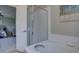 Bright bathroom showcasing a soaking tub with tile surround and a glass-enclosed shower at 13382 Franklin St, Thornton, CO 80241