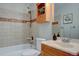 Bathroom with a shower-over-tub and wood-style vanity at 13382 Franklin St, Thornton, CO 80241