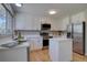 Bright kitchen with white cabinetry, stainless steel appliances, and a convenient center island at 13382 Franklin St, Thornton, CO 80241