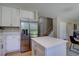 Modern kitchen with stainless steel refrigerator, white cabinets and a functional center island at 13382 Franklin St, Thornton, CO 80241