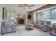 Cozy living room featuring a brick fireplace, plush sofas, a ceiling fan, and a large bay window at 13382 Franklin St, Thornton, CO 80241