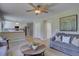 Bright living room with a glimpse into the modern kitchen, and an inviting gray sofa with throw pillows at 13382 Franklin St, Thornton, CO 80241