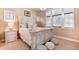 Airy bedroom showcasing a distressed wood bed frame, natural light, and comfortable seating at 5167 Morningside Way, Parker, CO 80134