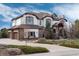 Beautiful two-story home with a three-car garage, stone accents, a landscaped front yard, and mature trees at 5167 Morningside Way, Parker, CO 80134