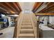View of the basement staircase with unfinished ceiling, leading to a laundry area at 1024 S Mobile St, Aurora, CO 80017