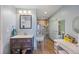 Bathroom with light blue walls, vanity, and glass enclosed shower at 1024 S Mobile St, Aurora, CO 80017