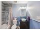 Bathroom with blue walls, stylish sink and vanity, and a tiled shower with bathtub at 1024 S Mobile St, Aurora, CO 80017