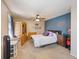 Bedroom with light walls, ceiling fan, a bed with purple pillows, and wooden furniture at 1024 S Mobile St, Aurora, CO 80017
