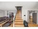 Inviting living room with staircase, cozy fireplace, and seamless flow to the adjacent kitchen at 1024 S Mobile St, Aurora, CO 80017