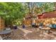 Charming backyard patio with stone fire pit, wood fence, and mature trees offering a cozy outdoor space at 3321 W 29Th Ave, Denver, CO 80211