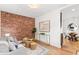 Stylish living room boasts exposed brick accent wall and hardwood floors, perfect for modern living at 3321 W 29Th Ave, Denver, CO 80211
