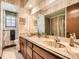 Bathroom with double sink vanity, patterned wallpaper, and window at 4000 S Dahlia St, Cherry Hills Village, CO 80113