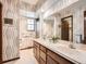 Bathroom featuring a dual sink vanity, ample lighting, and patterned wallpaper for a unique touch at 4000 S Dahlia St, Cherry Hills Village, CO 80113
