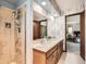 Bathroom featuring double sinks, patterned wall paper, and a walk-in shower at 4000 S Dahlia St, Cherry Hills Village, CO 80113