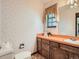 Compact bathroom showcasing charming wallpaper, window, and single vanity at 4000 S Dahlia St, Cherry Hills Village, CO 80113