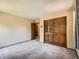 Bedroom with wood-paneled closet doors, neutral walls, and carpeting at 4000 S Dahlia St, Cherry Hills Village, CO 80113
