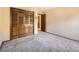 Bedroom showing a closet with wood-paneled doors, neutral walls, and carpeting at 4000 S Dahlia St, Cherry Hills Village, CO 80113